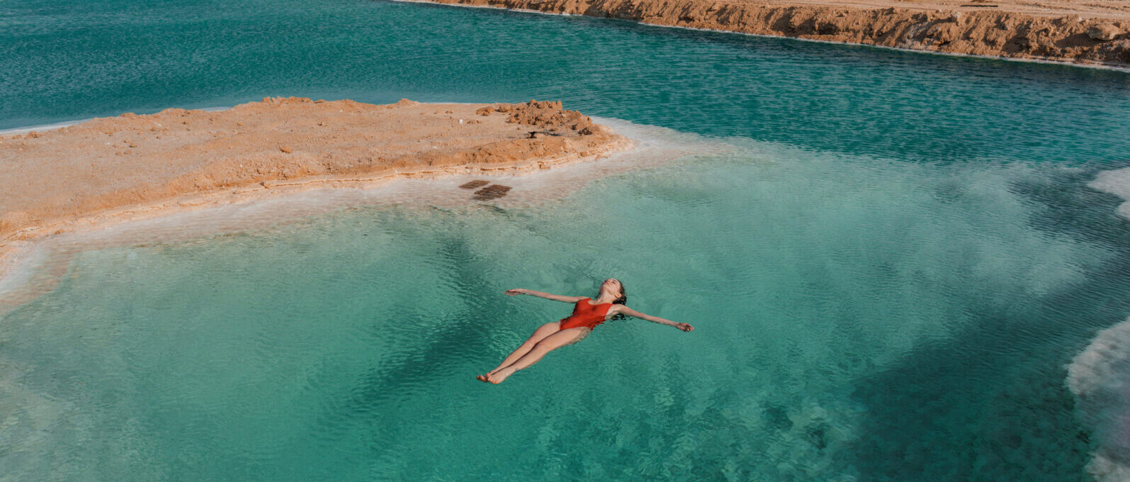 Woman swimming in salt lake in Siwa oasis, Egypt - best destination to travel in 2026