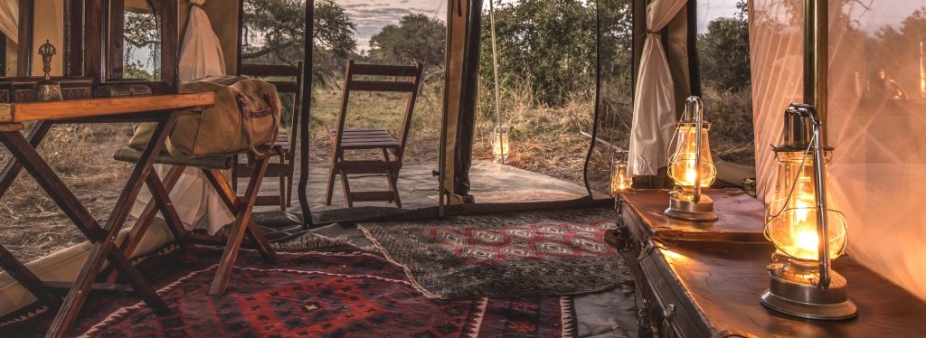 Interior of a Barclay Stenner tent, Persian rugs and a beautiful luxury safari view.