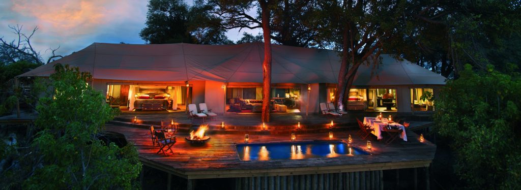 Exterior of the Zarafa canvas tents at nightfall. Luxury safari camp.