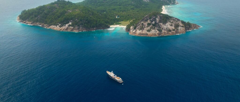 Luxury expedition boat sailing through the turquoise waters of the Seychelles and Tanzania.